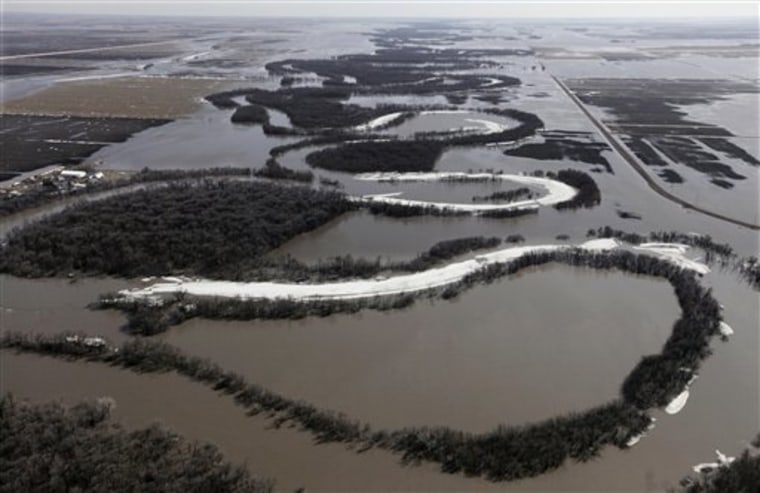 Flood waters from the swollen Red River spill over its bank and into surrounding farm land, Sunday, March 21, 2010, North of Fargo, N.D. The river crested earlier today at just under 37 feet, which is about four feet below the 2009 record level. (AP Photo/M. Spencer Green)